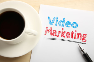 Text Video marketing written on the white paper with pen and a cup of coffee aside.